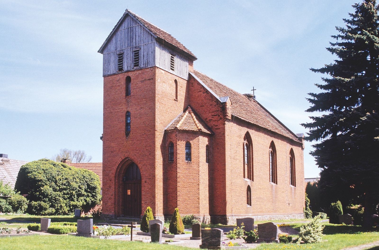 Dorfkirche Jederitz als neugotische Backsteinkirche mit Friedhof im Vordergrund